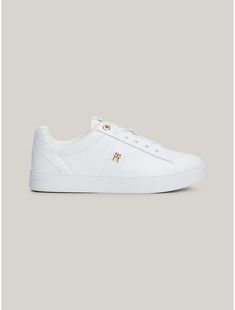 Tommy Hilfiger women's sneaker. Dial up your sporty luxe style in these leather sneakers, detailed with branded gold-tone eyelets and a polished TH monogram plaque.  Material: 100% Leather (fwa). Leather Low-top Sneakers With Foil Embossed Logo, Low-top Leather Sneakers With Foil Embossed Logo, Gold Luxury Sneakers With Metallic Logo, Luxury Gold Sneakers With Metallic Logo, Classic Tommy Hilfiger Leather Sneakers, White Leather Sneakers With Foil Embossed Logo, Elegant Low-top Sneakers With Perforated Toe Box, Tommy Hilfiger Sneakers Women, Tommy Hilfiger Sneakers