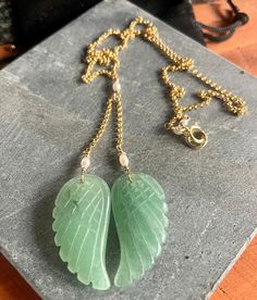 Embrace the soothing energy of our Aventurine Angel Wings Necklace.Meticulously crafted, this exquisite piece of jewelry on a gold filled chain showcases the calming green hues of Aventurine, delicate angel wings and symbolize the potential for growth, prosperity, and emotional healing in your life.  Material: Chain: 14 K Gold Filled Wings: Carved Aventurine Detailing: Fresh water Pearl Gold Chalcedony Jewelry As A Gift, Elegant Jade Pendant Crystal Necklace, Yellow Gold Chalcedony Jewelry Gift, Spiritual Aventurine Jewelry For Gifts, Elegant Wire Wrapped Jewelry For Meditation, Elegant Jade Crystal Necklace As Gift, Elegant Jade Crystal Necklace For Gift, Gold Chalcedony Jewelry For Anniversary, Elegant Wire Wrapped Necklaces