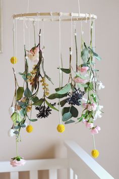 a mobile with flowers hanging from it's sides