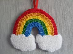 a crocheted rainbow ornament hanging on a wall