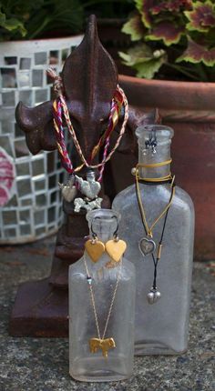 two glass bottles with necklaces in them