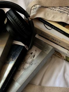 headphones and books on top of a bed