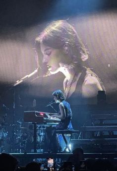 a woman is playing the piano on stage