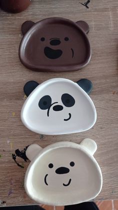 three panda bear plates sitting on top of a wooden table