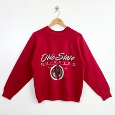 90s NCAA Ohio State University 'Buckeyes' Crewneck Sweatshirt Print Logo Red Color Men's Fit M - Made in Usa - Materials : Cotton, Polyester  - Tag Reads : L Fit M Kindly see the actual measurements (All measurements were taken lying flat) - Actual size manual measurements * Width (Armpit to armpit) : 22 inches * Length (Shoulder to end of garment) : 25 inches * Sleeve length : 22 inches - Condition : * Vintage condition 8/10 (80%) * Minor stain refer picture  * Free from tear and major defect - Shipping : * DHL Express/FedEx Express = 3-6 business day arrived * Please PROVIDE your PHONE/CONTACT NUMBER for SHIPPING/DELIVERY purpose DON'T FORGET TO VISIT MY SHOP FOR MORE GREAT STUFF, THANK YOU. Red Crew Neck Sweatshirt For Fan Merchandise, Red Crew Neck Sweatshirt For Fans, Vintage Red Crew Sweatshirt, Red Vintage Crew Sweatshirt, Vintage Red Crew Neck Tops, Retro Red Sweatshirt With Graphic Print, 90s Style Red Sweatshirt With Letter Print, Retro Red Graphic Print Sweatshirt, 90s Red Letter Print Sweatshirt