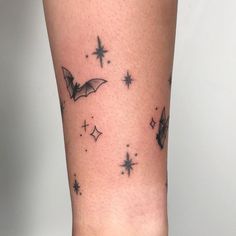 a small bat tattoo on the leg and it looks like stars are falling from the sky