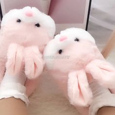 a pair of pink bunny slippers on top of a white floor next to a mirror