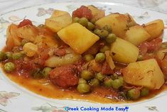 a white plate topped with potatoes and peas covered in gravy on top of a table