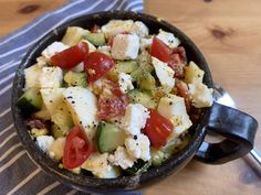 a bowl filled with salad sitting on top of a table next to a fork and napkin