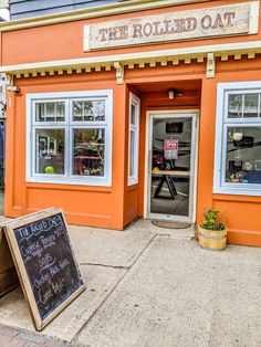 an orange building with a chalkboard sign in front of it that says the rolled oat