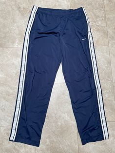 These pants are super hip, and ultra rare. They are old school Nike. They are clean and fresh. There is one spot with some pilling, it's near the waistband on the back, shouldn't be too noticeable. See the last photo. They must be bought to be worn.  Brand: Nike Size: XL Material: Polyester Measurements in inches Waist 36-40 Inseam 34 1/3.8 #33 I do accept returns within 30 days of purchase of all vintage items. The item must be in the same condition in which it shipped and preferably with the t Vintage Nike Pants, 2000s Pants, Nike Hose, Cold Fits, Nike Joggers, Nike Vintage, Y2k 2000s, Cute Outfits For School, Pants Blue