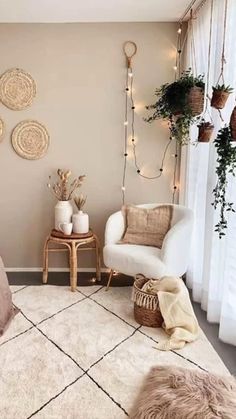 a bedroom decorated in neutrals and whites with lights strung from the ceiling, plants on the windowsill