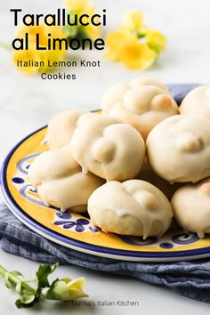 a plate filled with dumplings on top of a blue and yellow plate next to flowers