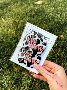 someone holding up a sticker with the words we are wild on it in front of some grass