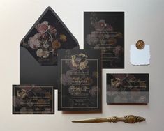 the wedding stationery is set up with black and gold accents, including an elegant floral design