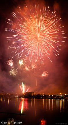 fireworks are lit up in the night sky over water