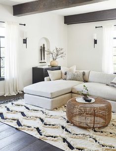 a living room with white furniture and black trim on the walls, windows, and rugs