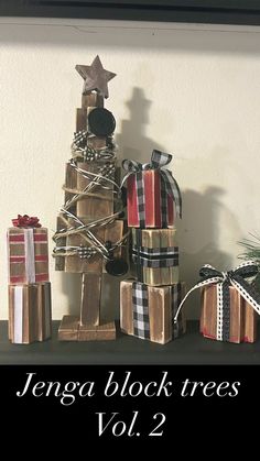 there is a small christmas tree made out of wooden blocks and wrapped presents on the shelf