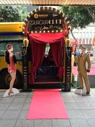 a man and woman standing in front of a bus on a red carpeted walkway