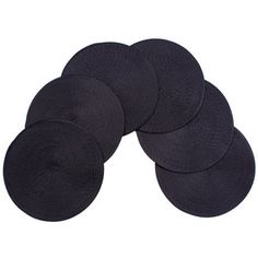 six black round placemats sitting on top of each other