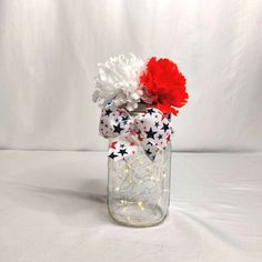 a mason jar filled with red, white and blue flowers