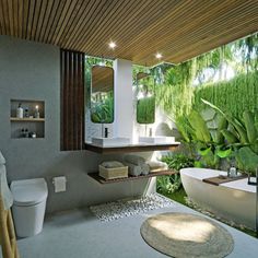 a bathroom with a bathtub, toilet and sink in front of a bamboo wall