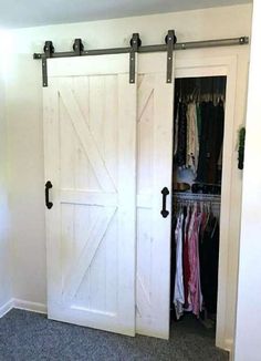 an open closet door with clothes hanging in it