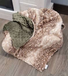 a pile of blankets sitting on top of a hard wood floor next to a door