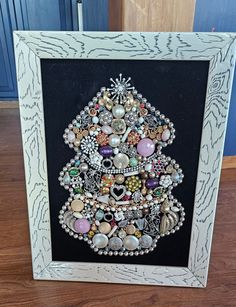 a christmas tree made out of buttons in a frame