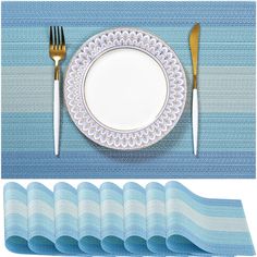 there is a plate, fork and knife on the blue placemats set next to each other