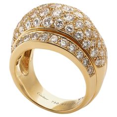 Created in the late 20th century, this Cartier diamond bombé or dome ring is set in 18K gold. The wide bombé center flanked by shaped bands are pavé-set with round brilliant-cut diamonds. Softly sculpted and pleasing in weight, this sleek, modern Cartier ring is playful and sparkling enough for the most glamorous possible cocktail hour. Product Details: Item #: R-20802 Artist: Cartier Country: France Circa: 1990's Size: 7.50, European 56 Materials: 87 round brilliant cut diamonds (with approximate total weight 4.5 carats); 18K Gold Signed: Cartier 750 607459 56 French importation marks Macklowe Gallery Curator's Notes: In the design of cocktail rings, which tend to be heavily weighted on the top, the most skilled jewelers engineer them to balance comfortably on the finger without flipping, Cartier Diamond, Cognac Diamonds, Pave Diamond Band, Gem Diamonds, Pave Diamond Ring, 18k Gold Ring, 18k Yellow Gold Ring, Pave Ring, Modern Ring