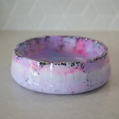 a pink and white bowl with black speckles on it