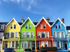 a row of multi - colored houses in front of a blue sky