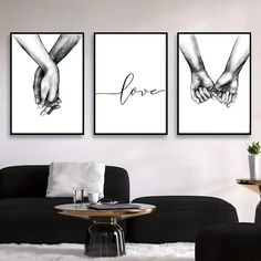 three black and white prints with hands holding each other's fingers, on a wall in a living room