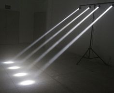 four spotlights are shining on the floor in an empty room with light coming through them