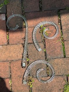 two metal objects sitting on top of a brick walkway