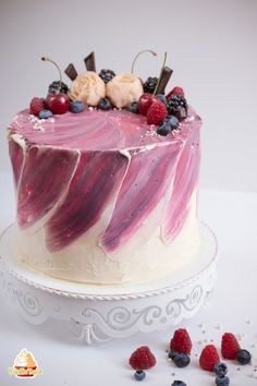 a cake with berries, raspberries and blueberries on top