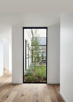 an empty room with wooden floors and glass doors that lead to the back yard area