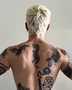 the back of a man with tattoos on his upper and lower part of his body