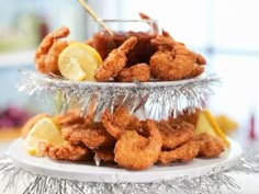 there is a platter full of fried shrimp and lemon wedges on the table