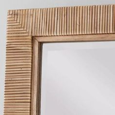 a wooden frame mirror hanging on the wall