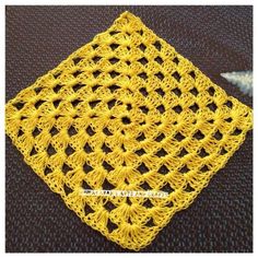 a yellow crocheted doily on a black surface