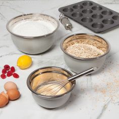 an assortment of ingredients are being prepared on a marble counter top, including eggs and flour