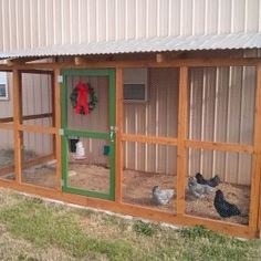 a chicken coop with two chickens in it and a wreath on the side of the building