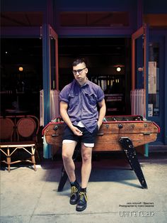 a man sitting on top of a wooden bench