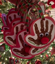 handprinted heart ornaments hanging from a christmas tree