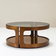 a glass and wood coffee table on a white surface with no one around it,