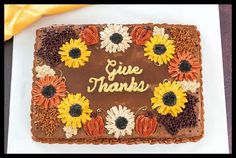 a chocolate cake with sunflowers and the words give thanks written on it