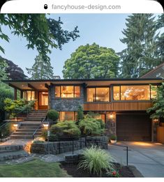 a large house with lots of windows and stairs leading to the front door, surrounded by trees