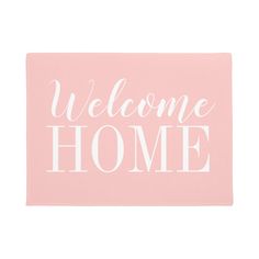 a pink welcome home mat with the words welcome home in white letters on top of it